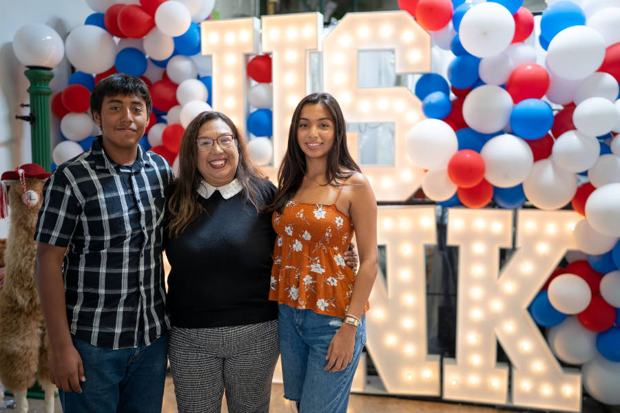Group of Latinos posing in front of US Bank sign